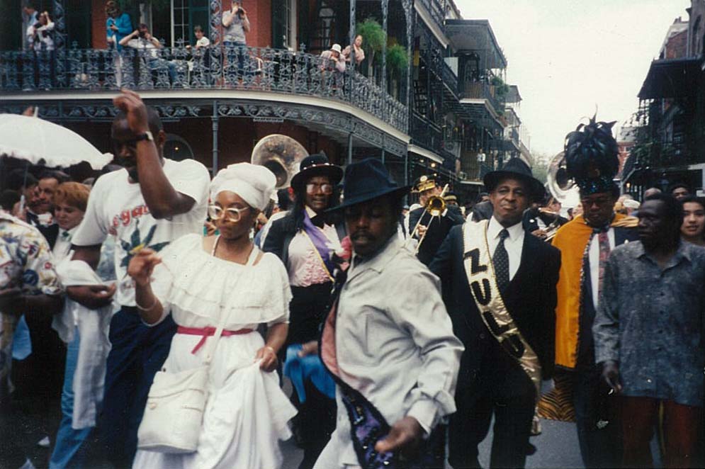 Members of the Krewe of Zulu marching and second-lining down French Quarter 